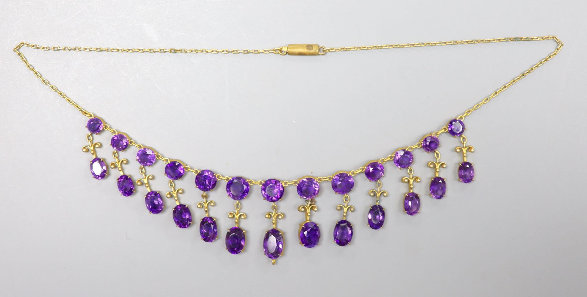 A 19th century gilt metal and oval cut amethyst set drop fringe necklace, 46cm (drop missing from bottom of necklace).